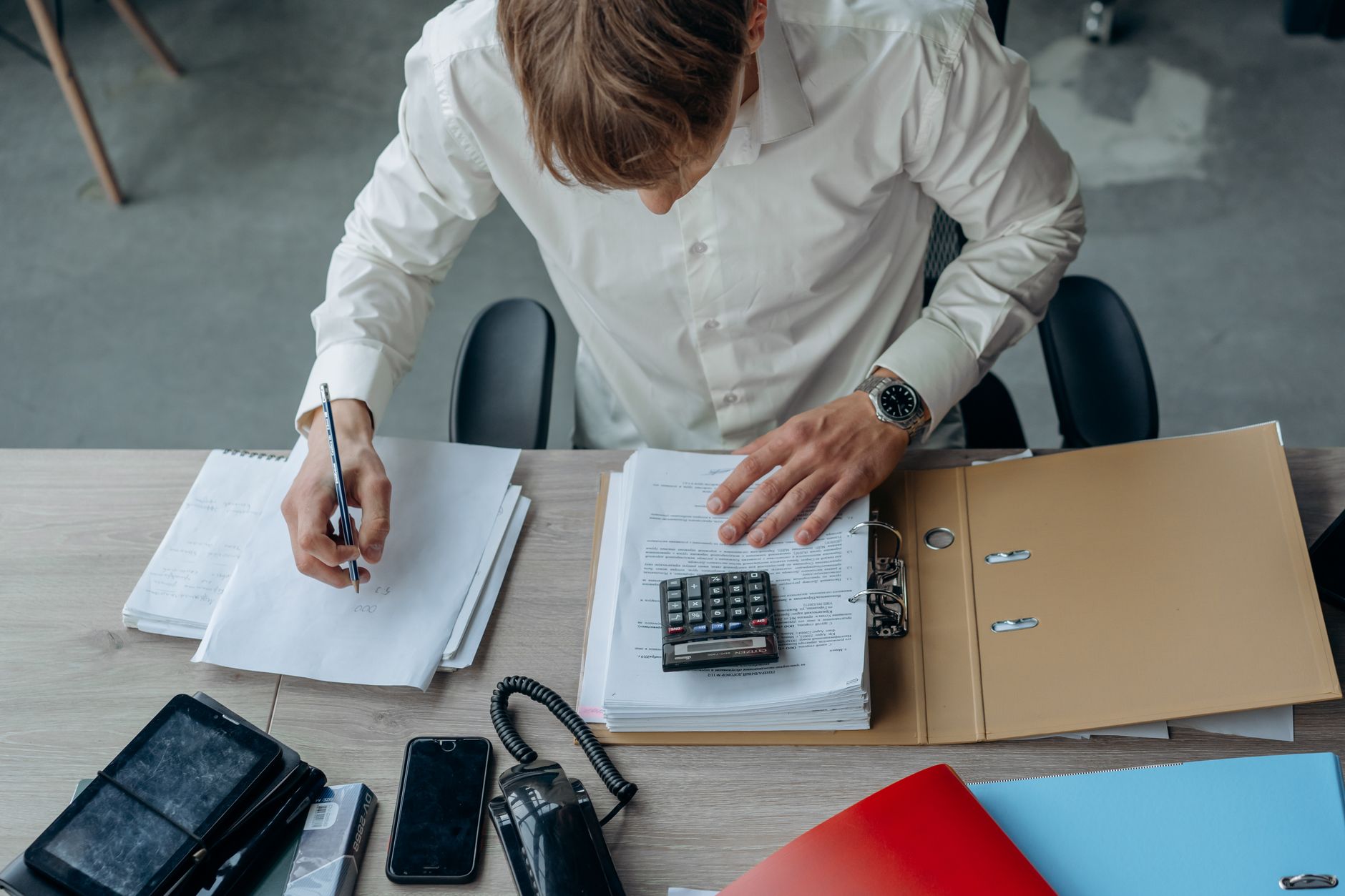 Founder reviewing financial paperwork with a calculator