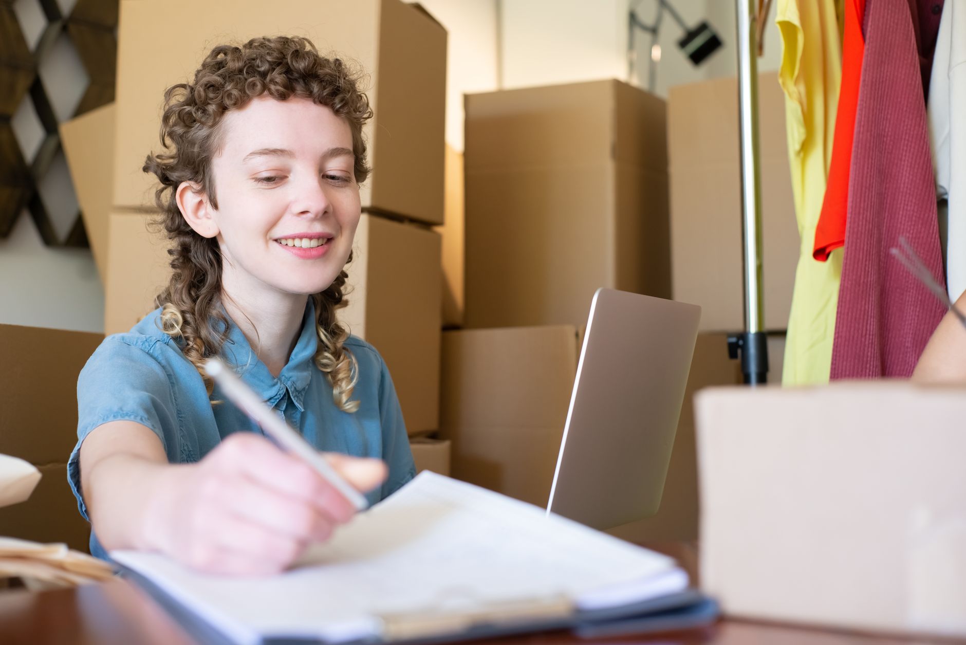 Ecommerce founder working at a laptop surrounded by shipping boxes