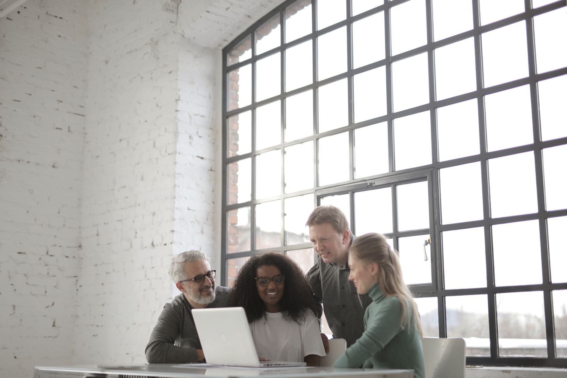 Startup team gathered around a laptop in an industrial office
